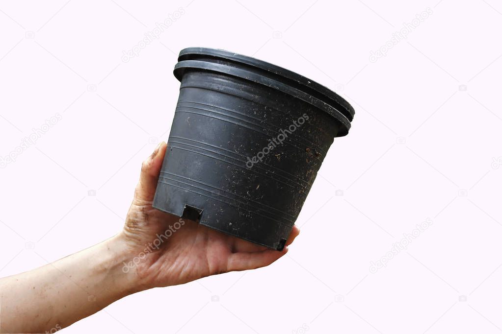 Isolated on white background of flower pots are held by dirty left hand.