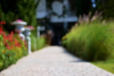 Restoran, bulanık giriş giderken yolun orada bitki, çiçekler, ağaçlar ve güzel dekore edilmiş.