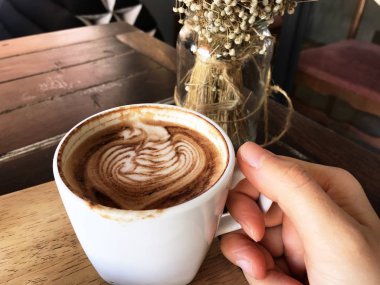 Bir kişi hangi kahve sanat caf tutan bir fincan mocha. Yazdırma Kupası kenarına, ağız.