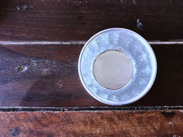 Κάτοψη Του Μικρά Ασημένια Μπολ Γεμάτο Νερό Στο Ξύλινο Τραπέζι — Φωτογραφία Αρχείου