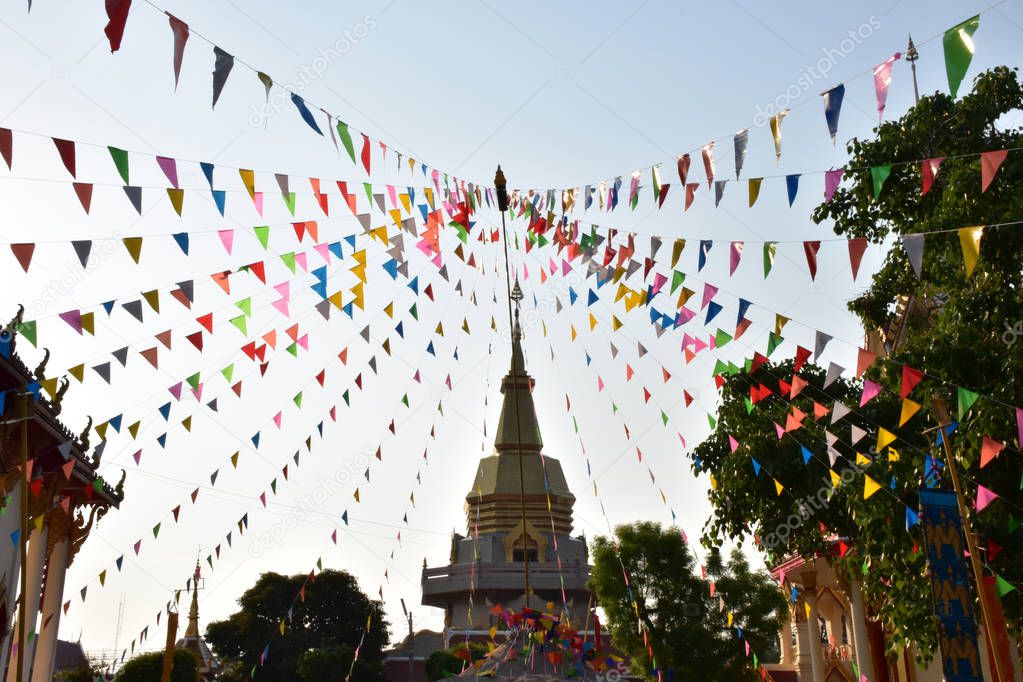 Colorful triangle flags fasten in line with pole in the temple ,  these are decorations in Song kran festival in Thailand.