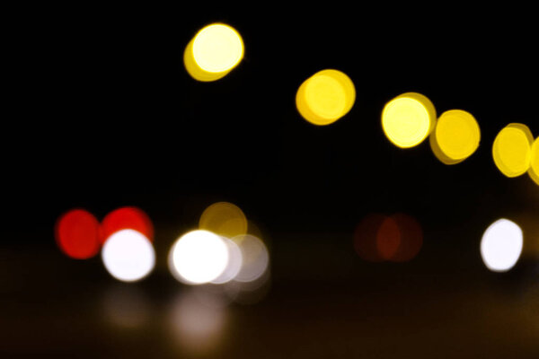 Color bokeh on a dark background, abstraction, background. Defocused blur across