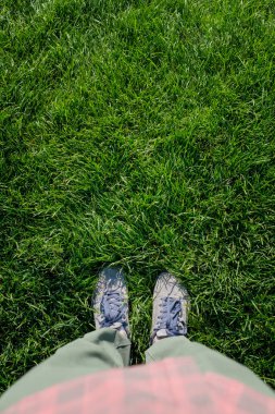 Bir adamın bacakları yeşil çim çerçevede bir üstten görünüm