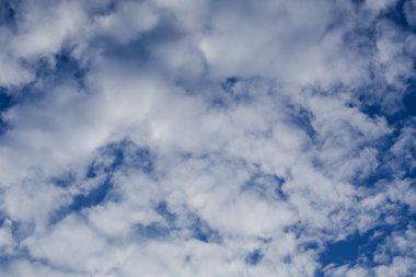 Beyaz bulutların üstünde açık havada mavi gökyüzünde.