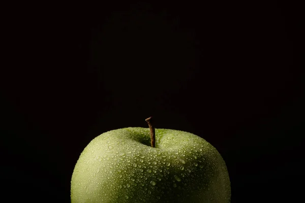 Πράσινο μήλο με σταγόνες νερού πάνω σε μαύρο φόντο. — Φωτογραφία Αρχείου