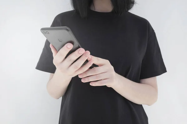 Молода жінка, використовуючи мобільний телефон, спілкується текстовими повідомленнями з другом. Концепція технології сучасного зв'язку — стокове фото