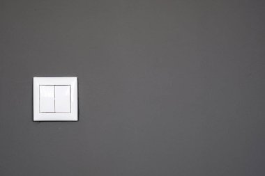 Koyu gri bir arka plan üzerinde, gri duvarda anahtarları. Ev elektrik anahtarı
