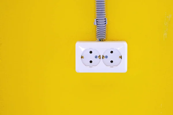 Toma eléctrica blanca en la pared amarilla. Enchufe en la pared amarilla. Copiar espacio . — Foto de Stock