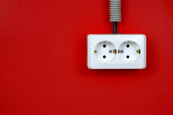 Salida de pared europea vacía, desenchufada, de cerca sobre fondo rojo. Toma eléctrica blanca en la pared roja. Primer plano. — Foto de Stock