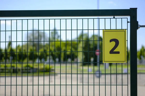 Maison numéro deux signe. Plaque jaune avec le numéro 2 sur une clôture métallique. Numéro deux (2) ) — Photo