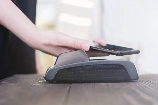 Mujer segura de pagar la factura a través de teléfono inteligente utilizando la tecnología NFC en la cafetería, la innovación en la vida cotidiana, espacio de copia —  Fotos de Stock