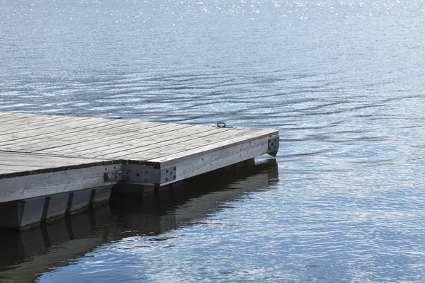 Anlegestelle am See. Holzbrücke im Frühling mit blauem See. See zum Angeln mit Steg. — Stockfoto