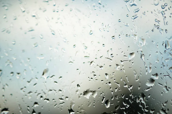 Rain drops on glass blur dim cafe background abstract — Stock Photo, Image