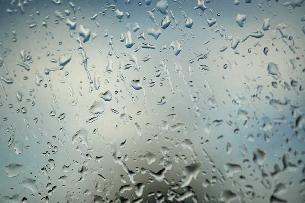 窗户上下着大滴雨。这是令人讨厌的一天。抽象蓝色背景和纹理，宏 — 图库照片