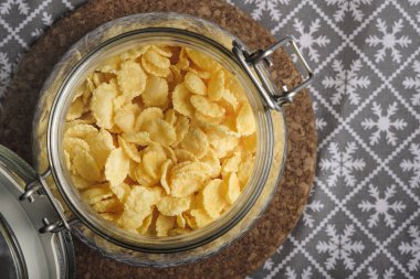 Masanın üzerinde cam bir kavanozda mısır gevreği, natürmort, konsept kahvaltı. 