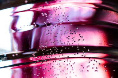 Küçük hava kabarcıkları pembe arka plan ile suda asılı