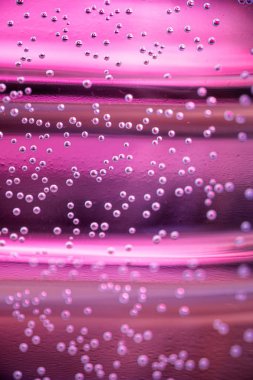 Renkli arka plan üzerinde arkadan aydınlatmalı su ve hava kabarcıkları Makro çekim. Su tabanı içinde küçük hava kabarcıkları.