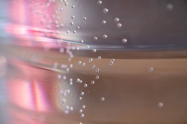 Birçok küçük hava kabarcıkları pembe bir arka plan üzerinde yüzen. Soyut renkli Arka Plan