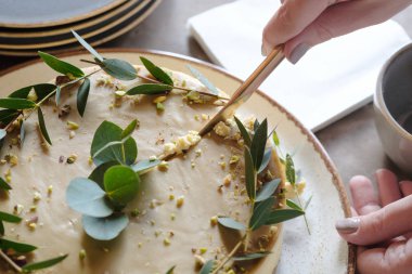 Kadının elleri pastayı kesti. Üstte görüntü 