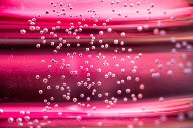 Renkli arka plan üzerinde arkadan aydınlatmalı su ve hava kabarcıkları Makro çekim. Su tabanı içinde küçük hava kabarcıkları.