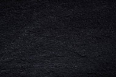 Koyu gri siyah arduvaz arka plan veya doğal taş dokusu.
