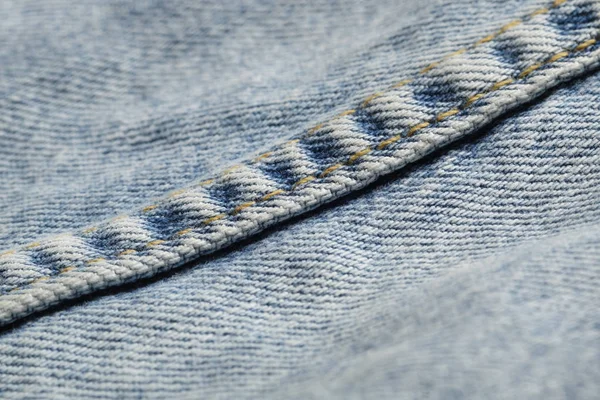 Biru jeans kain macro jahitan pola latar belakang kabur. Tekstur latar belakang denim untuk desain . — Stok Foto