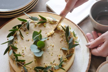 Kadının elleri pastayı kesti. Üstte görüntü 