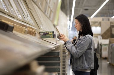 Güzel bir genç kız hırdavatçıda döşeme seçiyor.. 