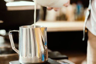 Barista paslanmaz çelik süt sürahisine süt döker. Kahveci için Latte sanatı. Kahve aksesuarları. Barista Kiti. 