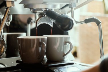 Kahve makinesinden dökülen espresso yakın plan. Profesyonel kahve demleme. Espresso makinesi barda, barda, restoranda kahve yapıyor. Sıcak içecek konsepti. 