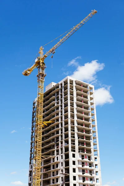 tower crane at a building site during the construction of blocks of flats. Detail of residential building under construction. Concrete structure with metal struts and temporary wooden railings