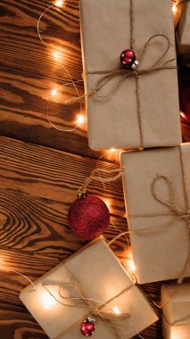 Noel kompozisyonu. Hediyeler, kırmızı süslemeler, Noel topları, Noel şekeri ve tahta bir arka planda çelenkler. Noel, kış, yeni yıl konsepti. Düz konum, üst görünüm, kopyalama alanı