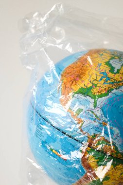 Dünya küresi plastik bir torba içinde. Çevre kirliliği. Gezegen tehlikede..