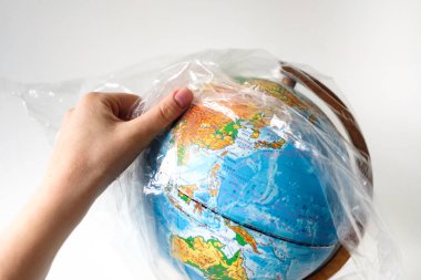 Dünya Çevre Günü konsepti. Bir insan eli yerden plastik bir torba çıkarır. Sosyal reklamlar için formda metne yer var. Plastiğe hayır! Dünyayı kirlilikten koru.