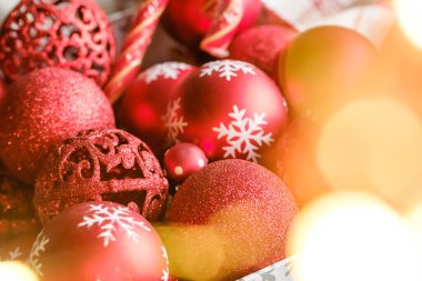 Kutuda kırmızı Noel oyuncakları, Noel ağacı süsleme hazırlığı. İçinde Noel ışıkları ve süslemeleri olan bir Noel kartı. Seçici odak.