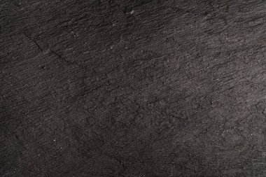 Koyu gri arkaplan ya da doğal taşın dokusu. Yakın çekim için siyah tahta.