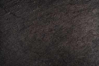 Koyu gri arkaplan ya da doğal taşın dokusu. Yakın çekim için siyah tahta.