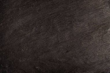 Koyu gri arkaplan ya da doğal taşın dokusu. Yakın çekim için siyah tahta.