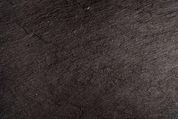 Koyu gri arkaplan ya da doğal taşın dokusu. Yakın çekim için siyah tahta.