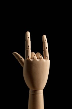 Çizim için kullanılan tahta el, rock n roll işareti, siyah arka planda rockçı hareketi gösteriyor. Yan görüş. Çizim için sanat modeli. Vücudun bir parçası - el, fırça.