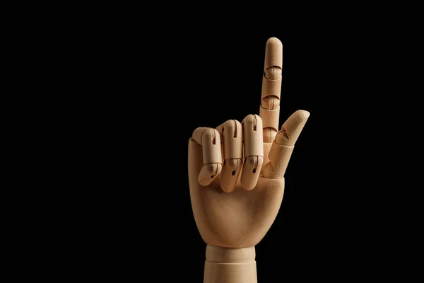 Wooden hand of mannequin for drawing indicates the direction of the index finger on a black background. Learning to count - one. Art model for drawing. Part of the body - hand, brush. Swipe up