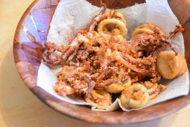 Ahşap tabakta kızarmış deniz ürünleri mürekkep balığı halkaları.