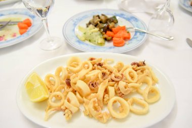 Tabakta kızarmış deniz ürünleri mürekkep balığı halkaları.