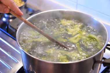 Ispanak kaynatıyorlar, adam yemek pişiriyor. 