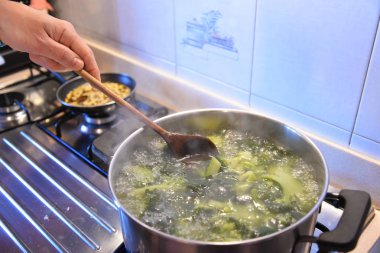 Ispanak kaynatıyorlar, adam yemek pişiriyor. 