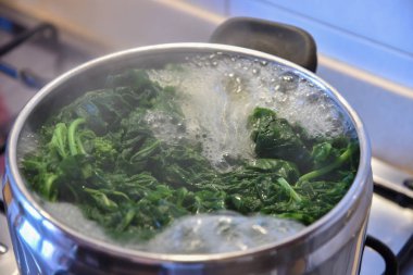 Tavada kaynar su ve ıspanak.