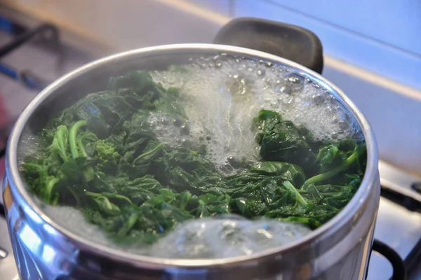 Tavada kaynar su ve ıspanak.