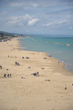 Sahilde yürüyen insanlar