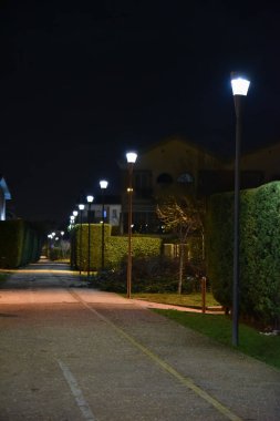 Lambalar ile aydınlatılmış çit ile gece yolu