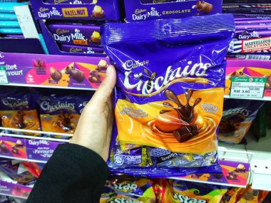 Kadınlar süpermarkette çikolata tutan el. Seçilen odak. Bulanık.